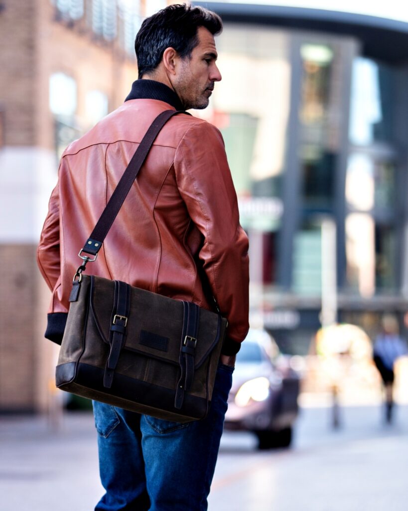 Rear view of a professional man wearing a waxed canvas Builford cross-body bag, showcasing the durable strap and vintage design.