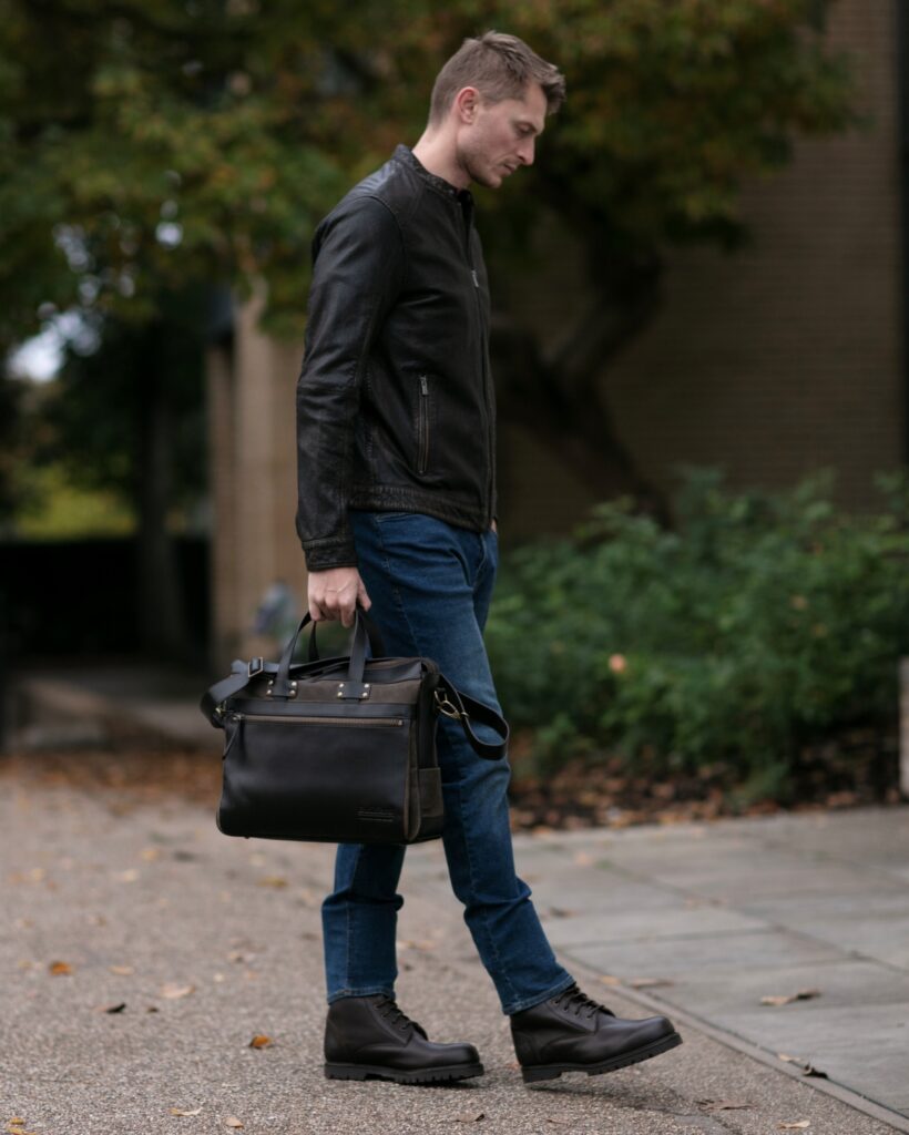 Detailed view of heavy-duty brass hardware and reinforced leather strap on Builford waxed canvas bag